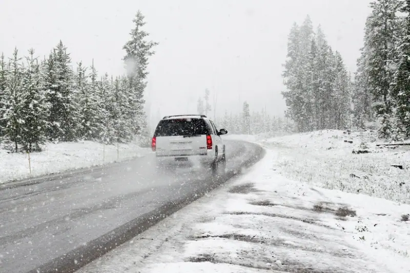 Route enneigée avec un véhicule circulant en hiver